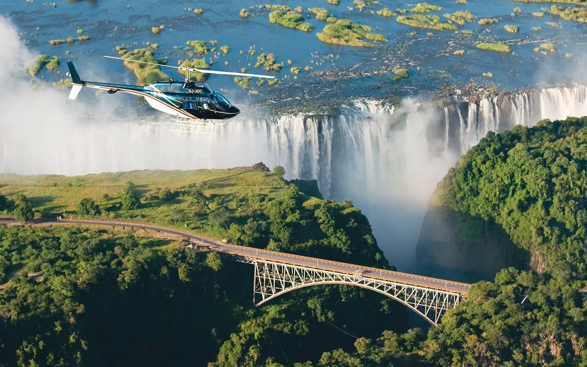 A rainbow in the spray of Victoria Falls seen from a helicopter