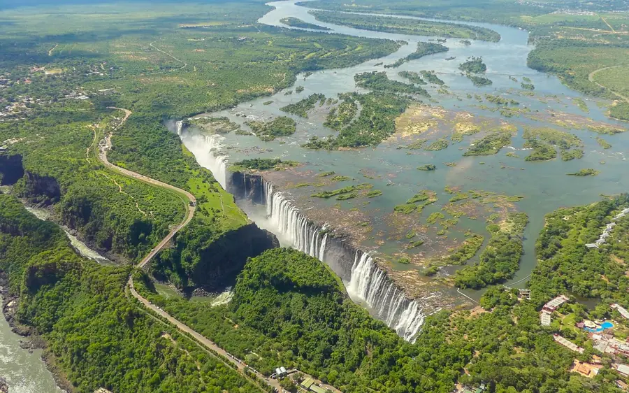 A helicopter above the full curtain of Victoria Falls